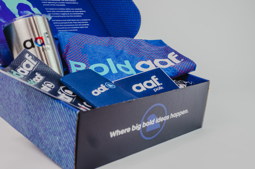 Custom kit box designed for AAF Polk with a tee shirt, tumbler, koozie. Side angle of the box.