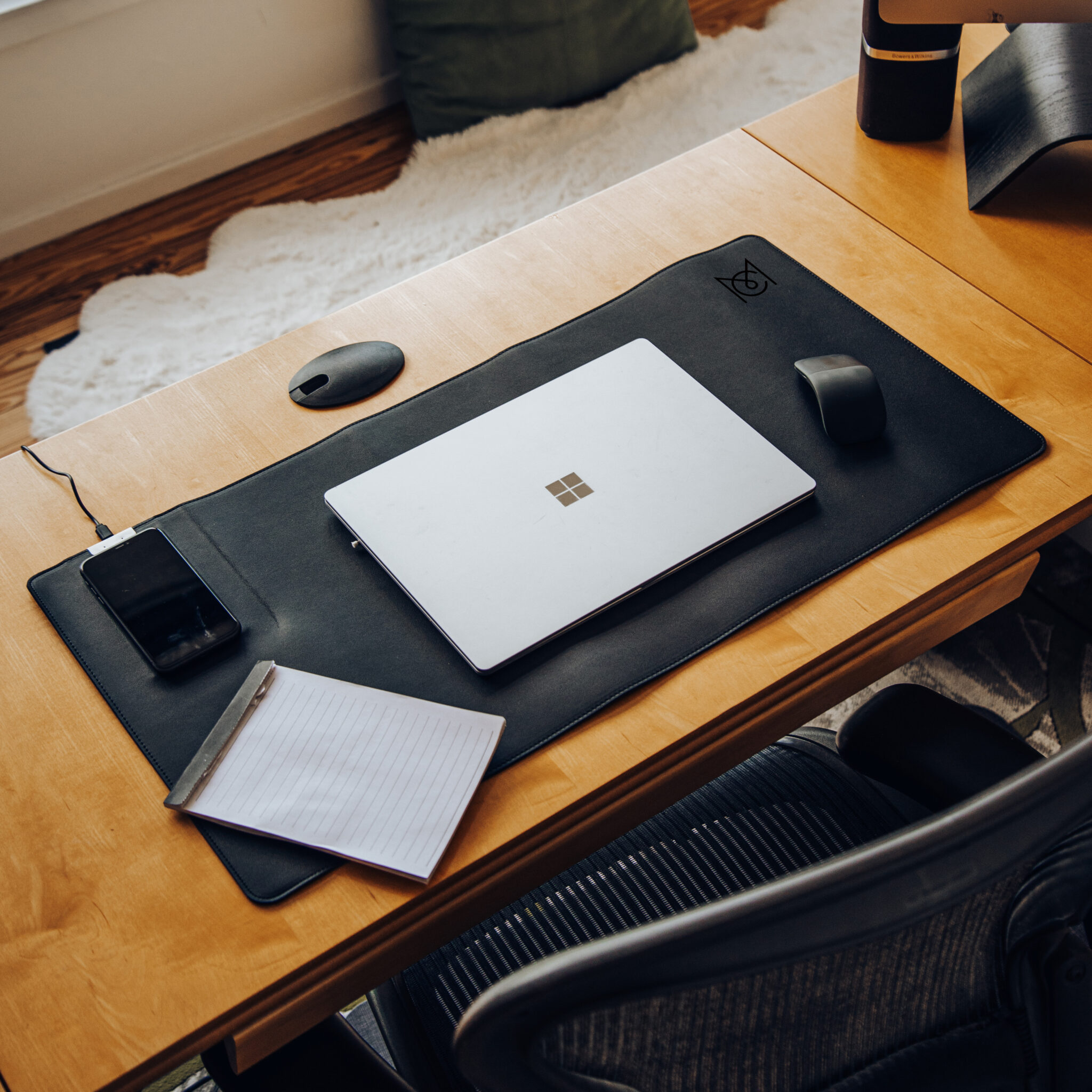 A home office photo with a computer and iphone on a desk.