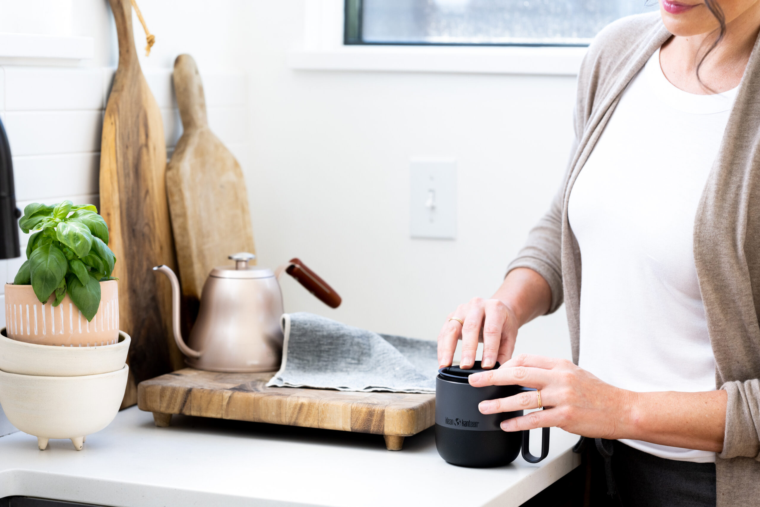 A woman holding a mug in her kitchen.