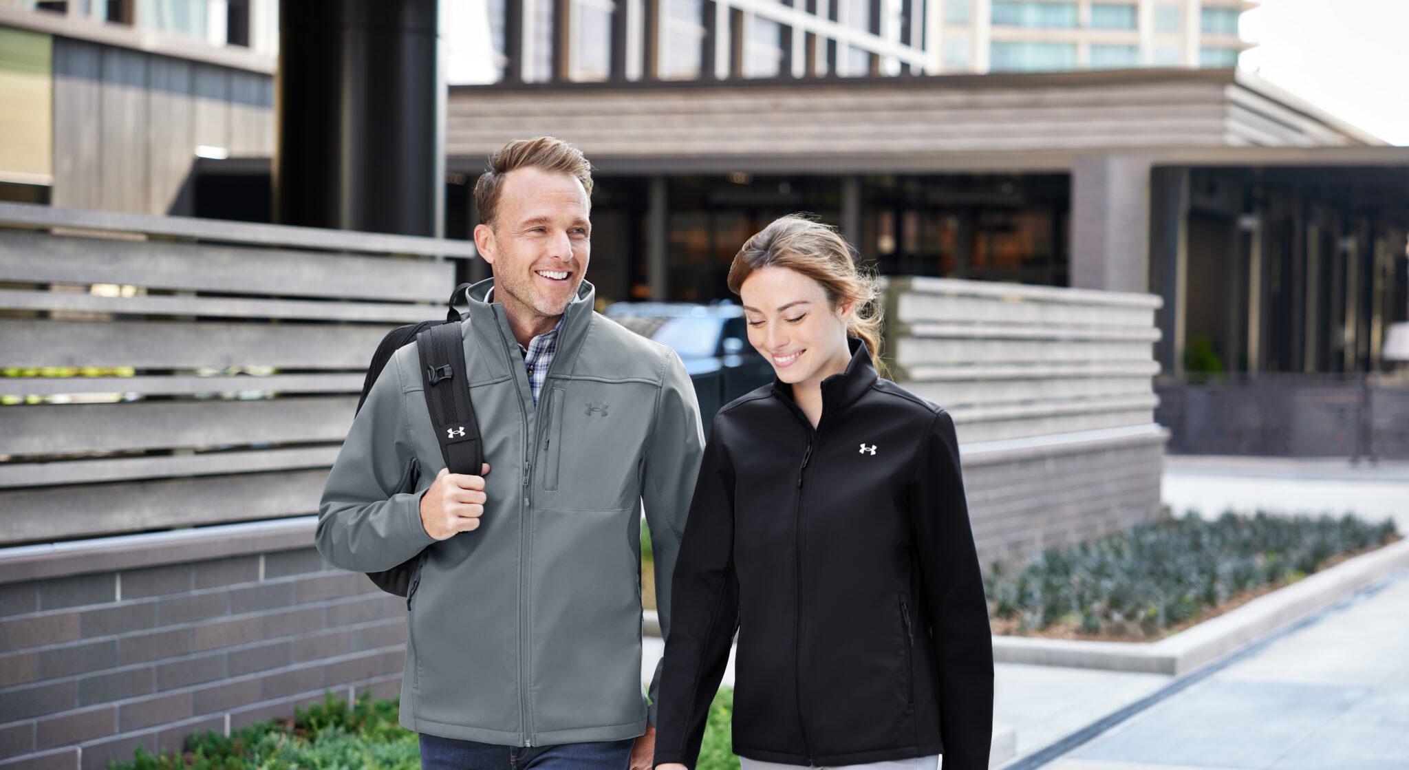 A young couple walking in underarmor jackets