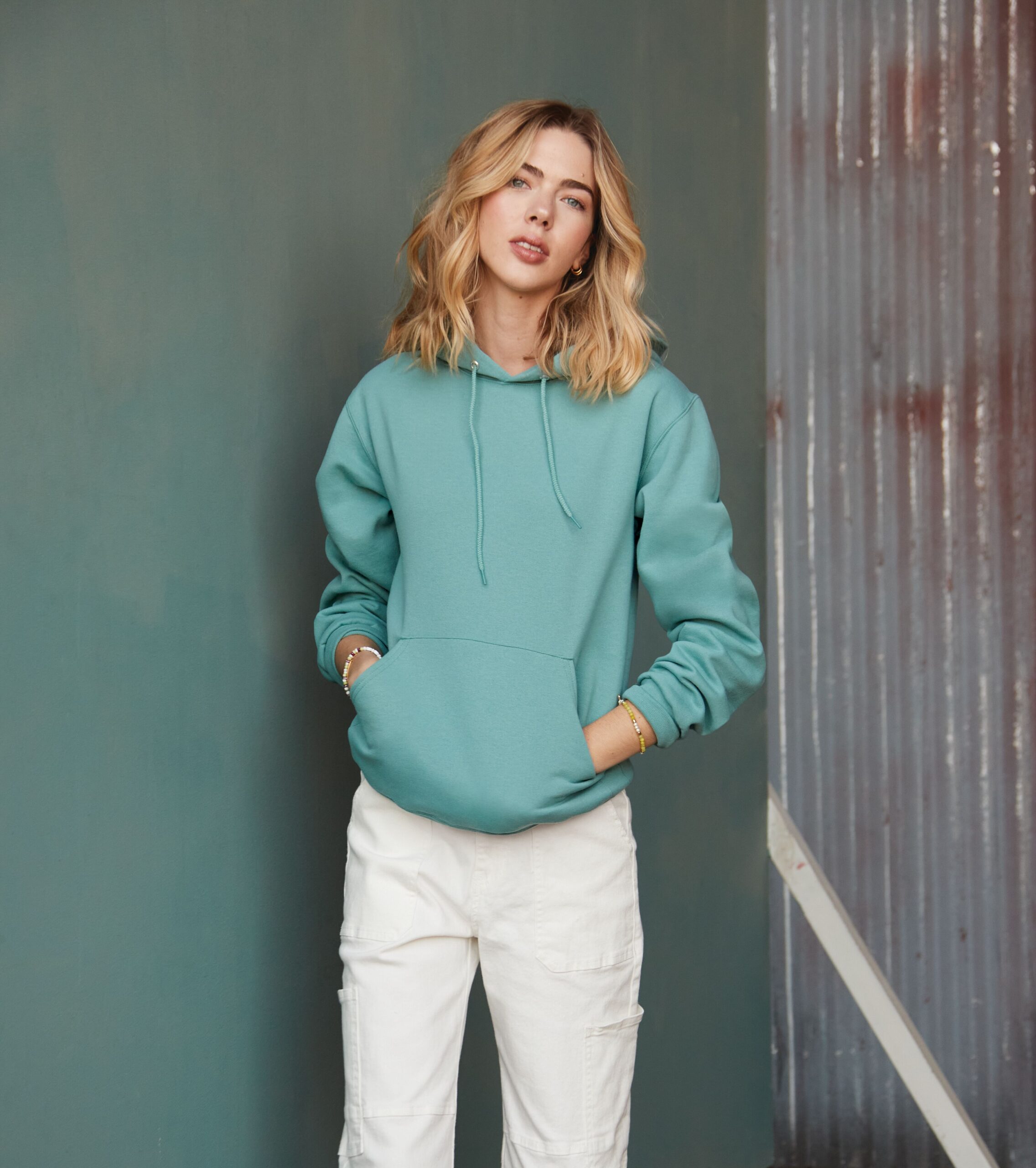 A young woman posing in a blue hoodie