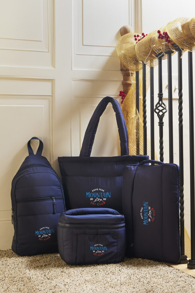 A collection of different types of bags in blue placed at the top of the stair case.