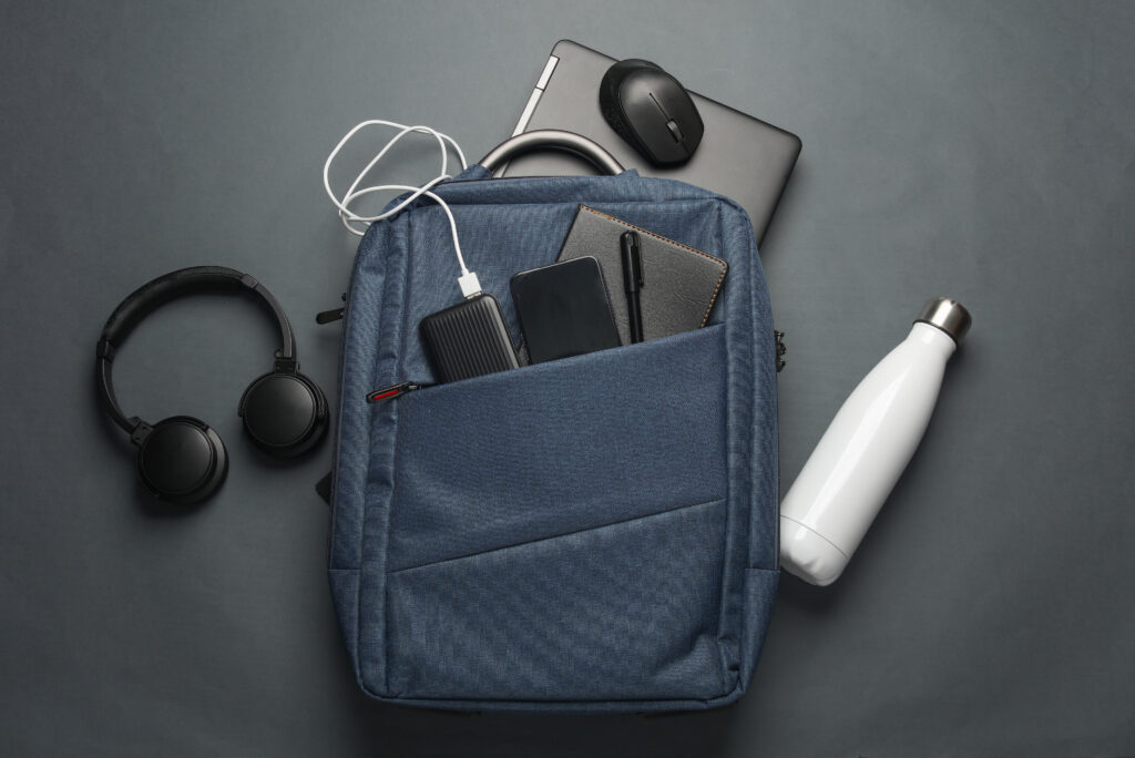 Office accessories including a backpack, water bottle, headphones, charging bank and mouse.