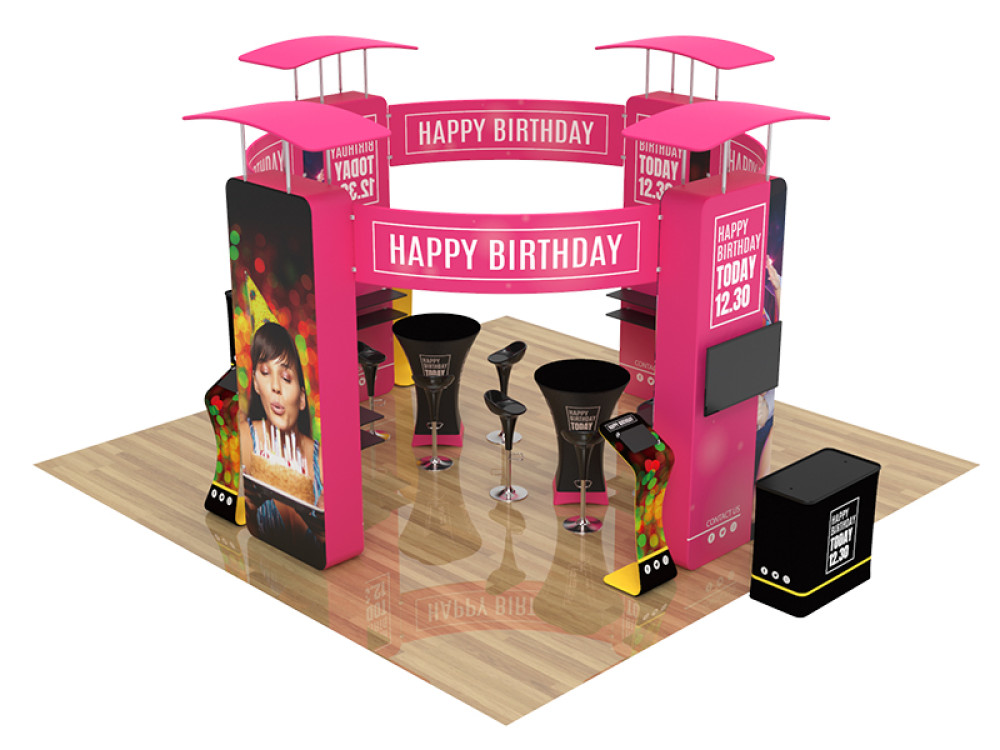 A pink tradeshow display with circular tall signage with the statement Happy Birthday on the front. There are two high top tables and chairs in the middle of the circular signage stand.