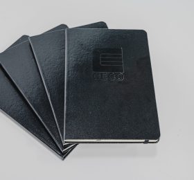 Stacked notebooks in the color black with the logo Ceco on top.